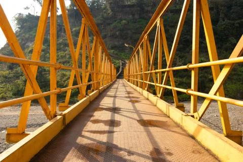 Yellow steel bridge over river in himachal pradesh in Kangra village, india Stock Photos