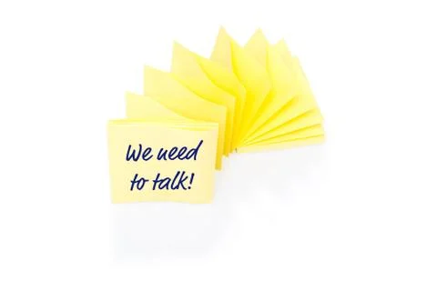 Yellow sticky note on block with message We Need To Talk Stock Photos