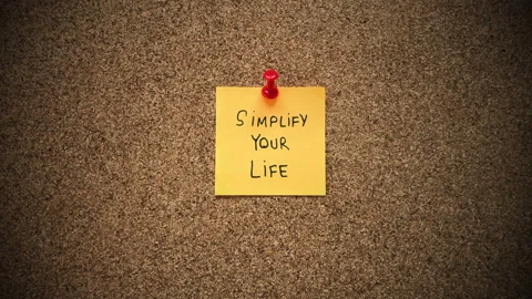 A yellow sticky note with the phrase Simplify Your Life written on it. Stock Footage 301322435