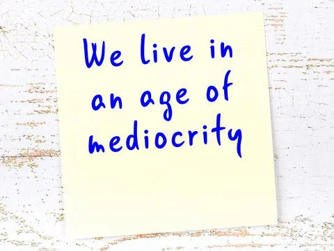 Yellow sticky note with smart quotation handwritten on it hanging on wooden w 写真素材