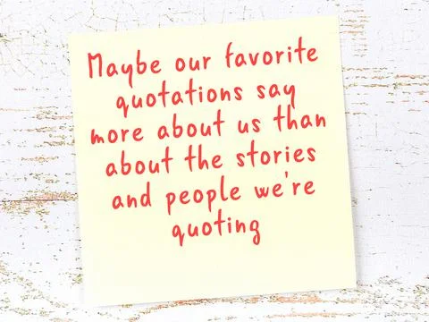 Yellow sticky note with smart quotation handwritten on it hanging on wooden w 库存照片