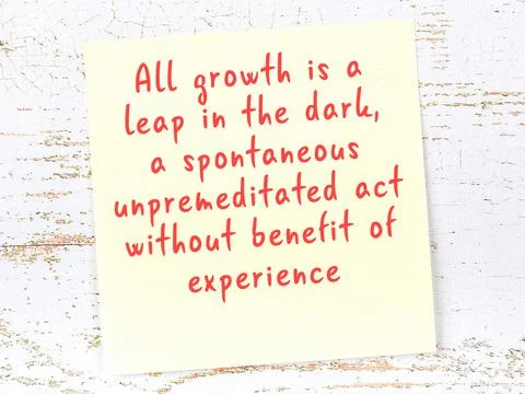 Yellow sticky note with smart quotation handwritten on it hanging on wooden w Stock Photos
