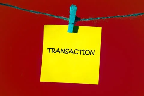 A yellow sticky note with the term transaction hangs on a string, set again.. Stock Photos
