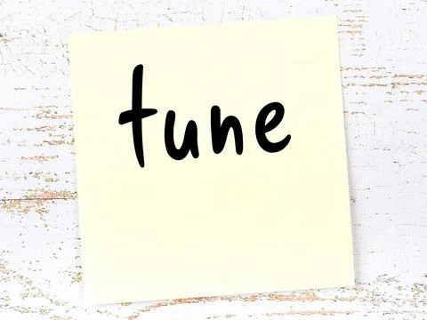 Yellow sticky note on wooden wall with handwritten inscription tune Illustrazione stock