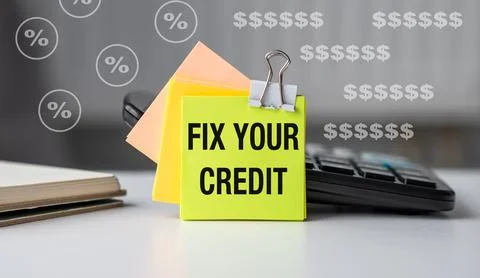 A yellow sticky note with the words Fix Your Credit on it Stock Photos