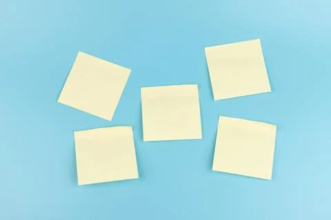 Yellow sticky notes on blue background. Square sticky paper reminders with sh Stock Photos