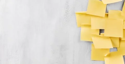 Yellow sticky notes on a gray wall with open copy space on the left Stock Photos