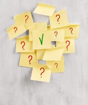 Yellow sticky notes show red question marks and one green check mark Stock Photos