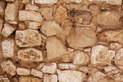 Yellow stone wall on a building as a background. The natural texture of the Stock Photos
