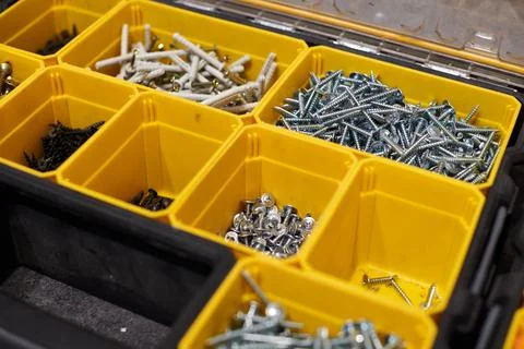 Yellow storage case with screws, nuts, bolts, nails and other small tools for Stock Photos