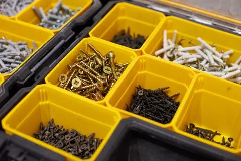 Yellow storage case with screws, nuts, bolts, nails and other small tools for Stock Photos