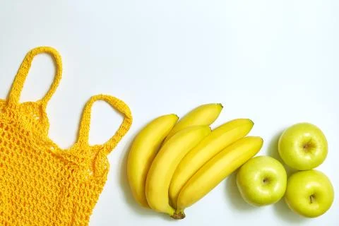 Yellow string bag, bananas and apples top view. flat lay with copy space Stock Photos