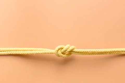 Yellow string knotted on a orange colour background Stock Photos