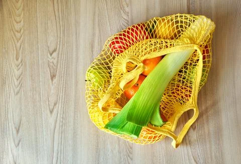 Yellow string shopping bag with vegetables and fruits Stock Photos