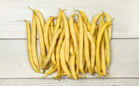 Yellow string (wax) beans on white boards. Tabletop view. Stock Photos