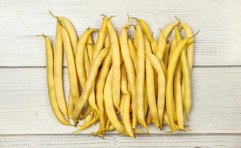 Yellow string (wax) beans on white boards. Tabletop view. Yellow string (w... Stock Photos