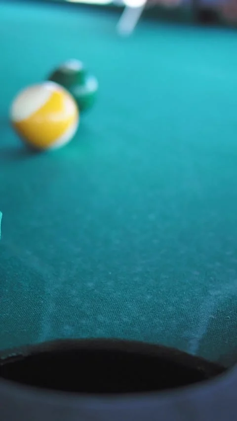 Yellow Striped Pool Ball Sinking into Pocket on Green Table Stock Footage 333816328
