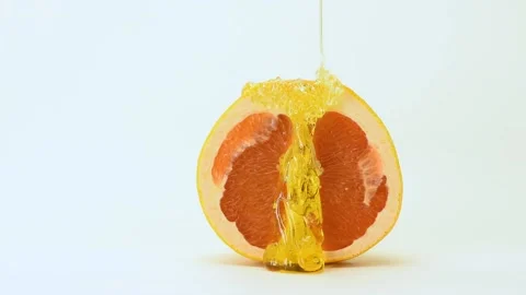 A yellow sugar paste for epilation is poured on top of a grapefruit. Video stock 164587490