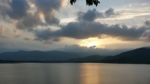 The yellow sun behind the silhouette of the cloud and mountain Stock Footage 153744486