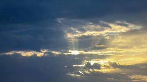 Yellow sun rays from grey clouds Stock Photos