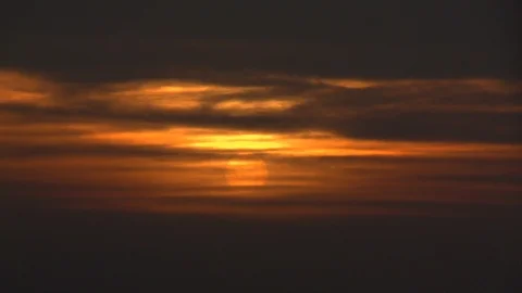 Yellow Sun Setting Through Orange Clouds Over Dark Horizon Stock Footage 103860185