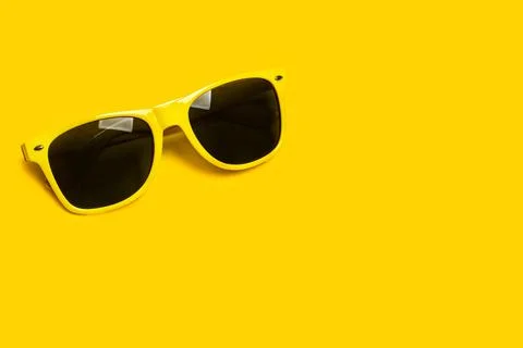 Yellow sunglasses on a yellow background with copy space Foto stock