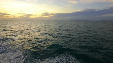 Yellow sunrise cloud n dark gray cloudscape over sea water waves Stock Footage 153899252