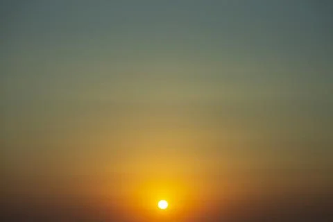 A yellow sunset disk in the orange gradient evening sky Stock Photos