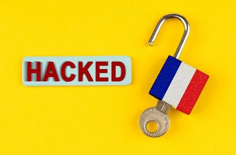 On a yellow surface, an open lock with the image of the French flag and a sti Stock Photos