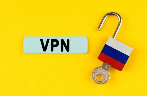 On a yellow surface, an open padlock with the image of the flag of Russia wit Fotos de archivo