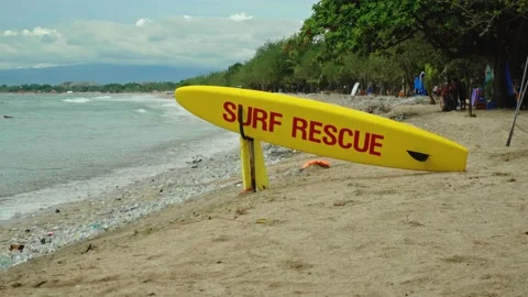 Yellow surfboard on beach with red text surf rescue emergency on a beach Stock Footage 146464915