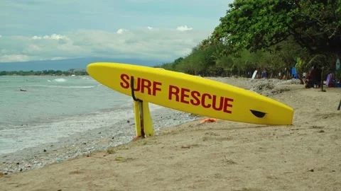 Yellow surfboard on beach with red text surf rescue emergency on a beach Stock Footage 146465160