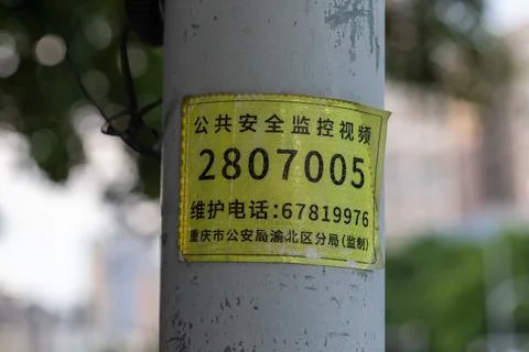 Yellow surveillance video camera identifier label on a pole Stock Photos