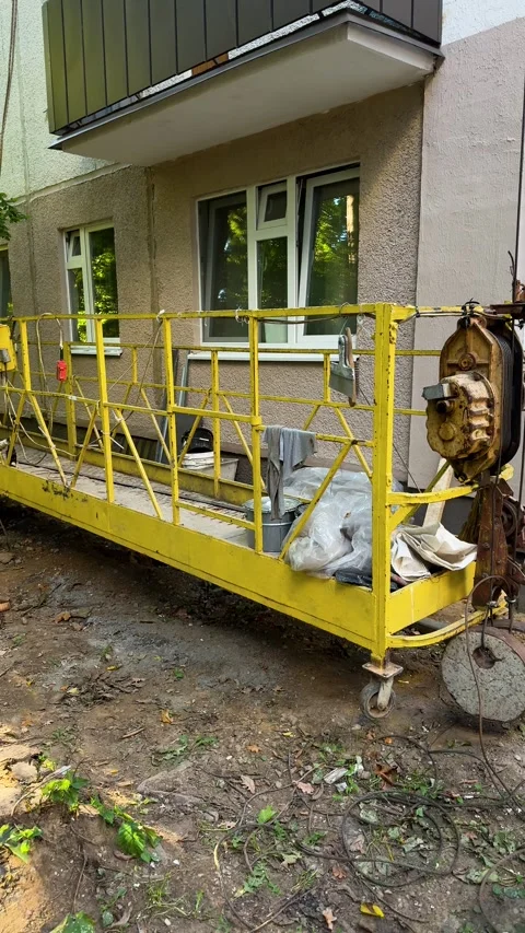 Yellow suspended work platform with electric hoist  Vídeo Stock 347516104