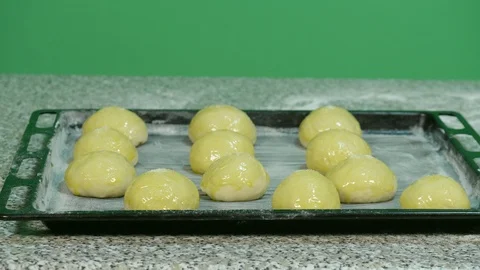 Yellow sweets on rotating baking sheet - green screen background Stock Footage 126613372
