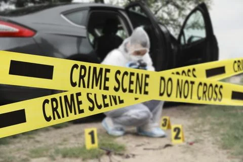 Yellow tapes blocking way to crime scene. Criminologist working outdoors Stock Photos
