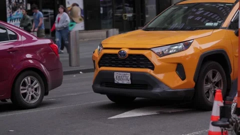 A Yellow Taxi navigating through the bustling Times Square traffic amidst the Stock Footage 314577861