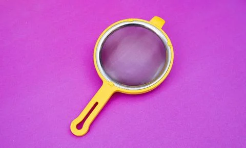 Yellow Tea Strainer on Pink Background Stock-Fotos