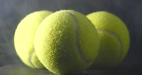 Yellow tennis balls resting on table smoke rising playing the game Video stock 206836799