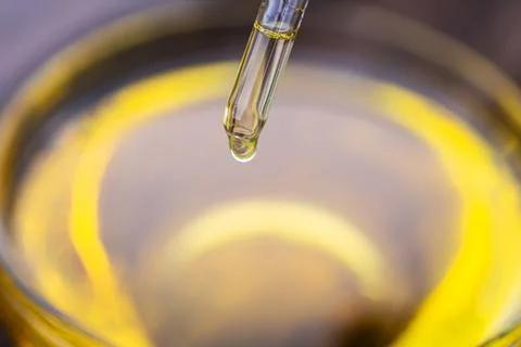 Yellow texture of a drop of whey or olive oil on a yellow background. Transpa Stock Photos