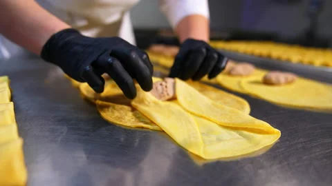 Yellow thin crepe being rolled around meat stuffing.  Video stock 195679490