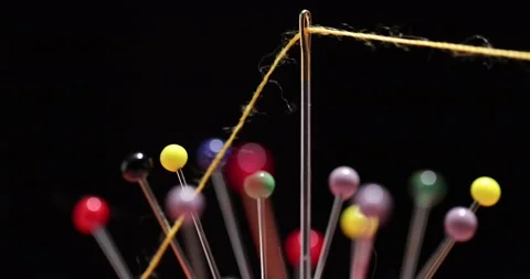 Yellow thread passing through the eye of the needle, close-up Stock Footage 168364026