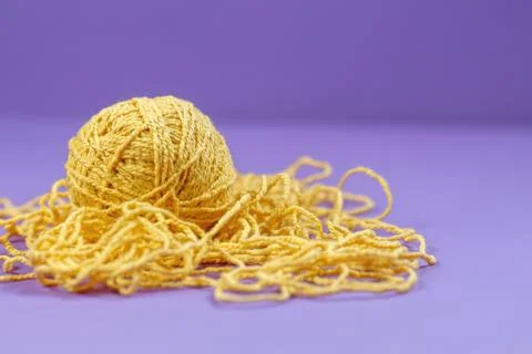 Yellow threads for creativity on a purple background Stock Photos
