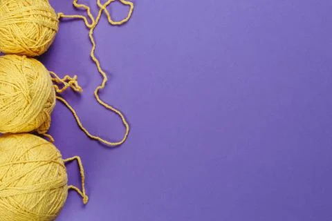 Yellow threads for creativity on a purple background Stock Photos