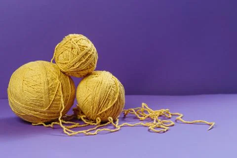 Yellow threads for creativity on a purple background Stock Photos