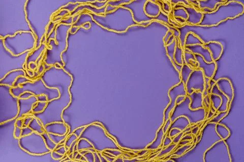 Yellow threads for creativity on a purple background Stock Photos