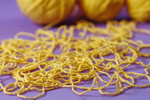 Yellow threads for creativity on a purple background Stock Photos