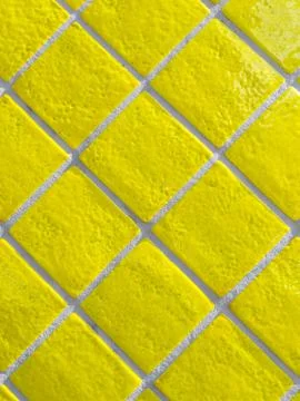 Yellow tiled wall pattern with textured glazed surface Foto stock