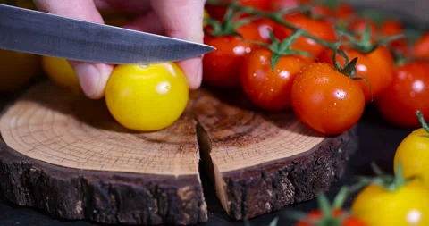 A yellow tomato cut into half and wet round fresh and sweet tomatoes of red and Stock Footage 328089437