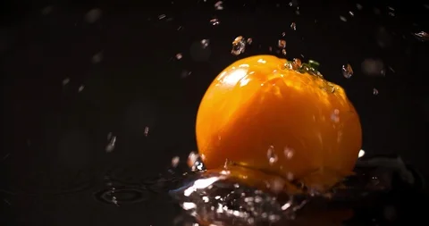 Yellow Tomato slow motion closeup falling in water macro Stock Footage 124763729